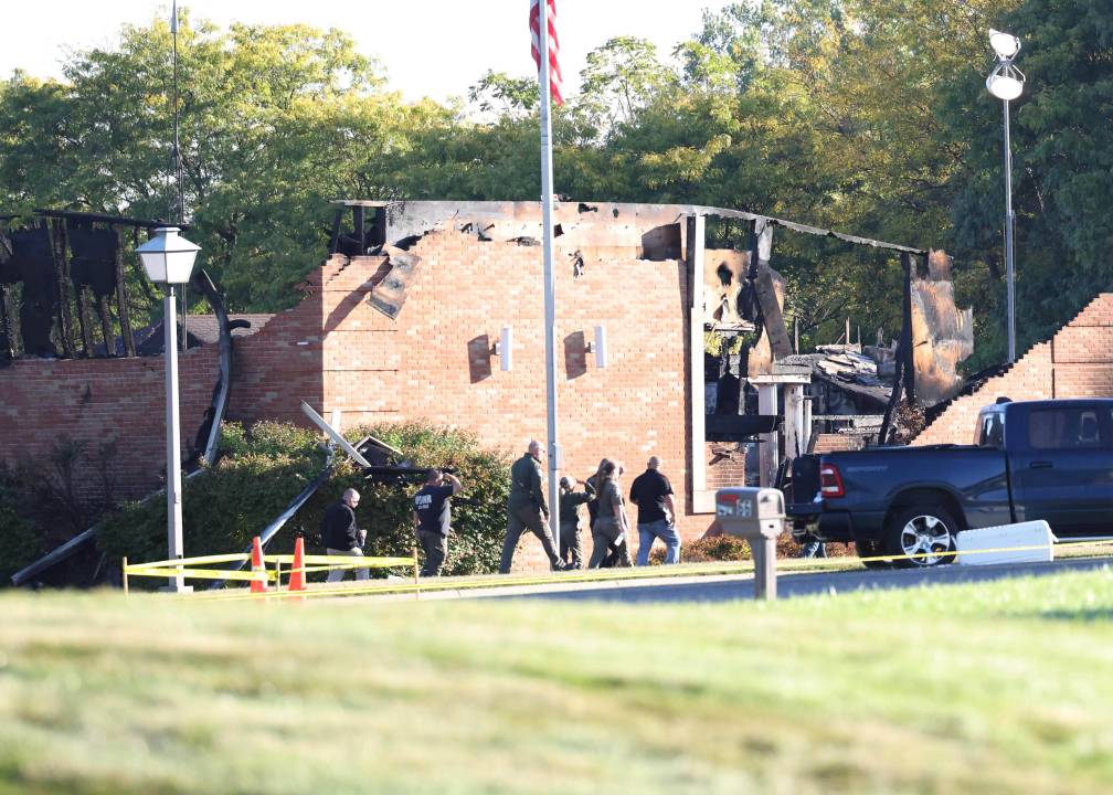 Law enforcement officers walk outside a building