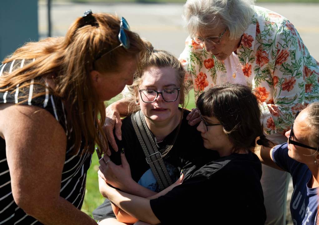 People comfort each other at the scene of a shooting and fire at a church in michigan