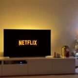 In einem weihnachtlich geschmückten wohnzimmer steht ein fernseher, auf dem netflix läuft.
