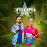 Dschungelcamp 2026 moderatoren jan köppen und sonja zietlow stehen in bunten trainingsklamotten vor einer dschungelkulisse.