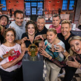 Die teilnehmer der diesjährigen staffel „das große promibacken“ stehen als gruppe um den goldenen cupcake herum und schauen in die kamera. Arabella kiesbauer; rené casselly; rebecca immanuel; alexander mazza; paula lambert; thomas hermanns; anne-sophie briest; thomas helmer; maximilian arland; anna-carina woitschack