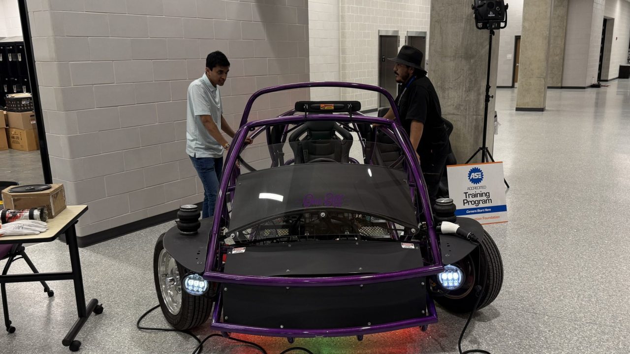 Students next to an electric car