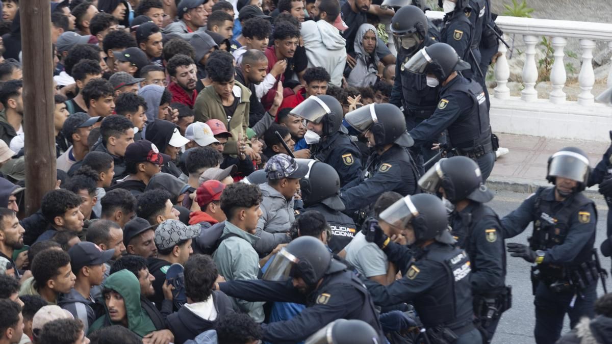 Los antidisturbios contienen a los inmigrantes el 18 de septiembre antes de su traslado al campamento creado en el puerto de Ceuta.