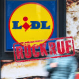 Ein Lidl-Schild mit Produktbildern im Hintergrund, davor eine verschwommene Person