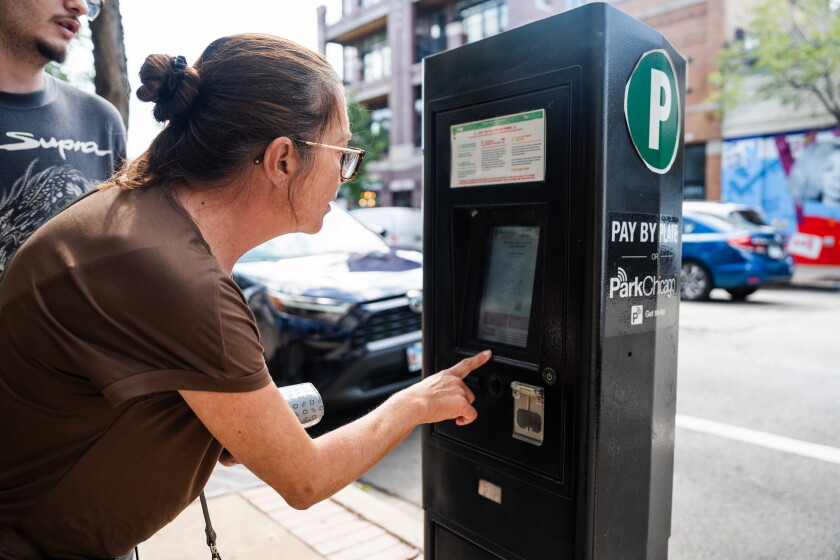A driver pays for parking on ParkChicago’s pay station on North Clark Street in Andersonville earlier this month.