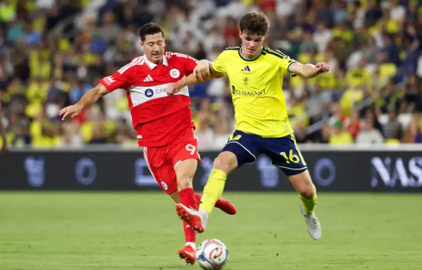 Matthew Corcoran #16 of the Nashville SC and Robert Lewandowski #9 of the Chicago Fire FC battle for the ball during the first half of the match at GEODIS Park on September 19, 2026 in Nashville, Tennessee. 