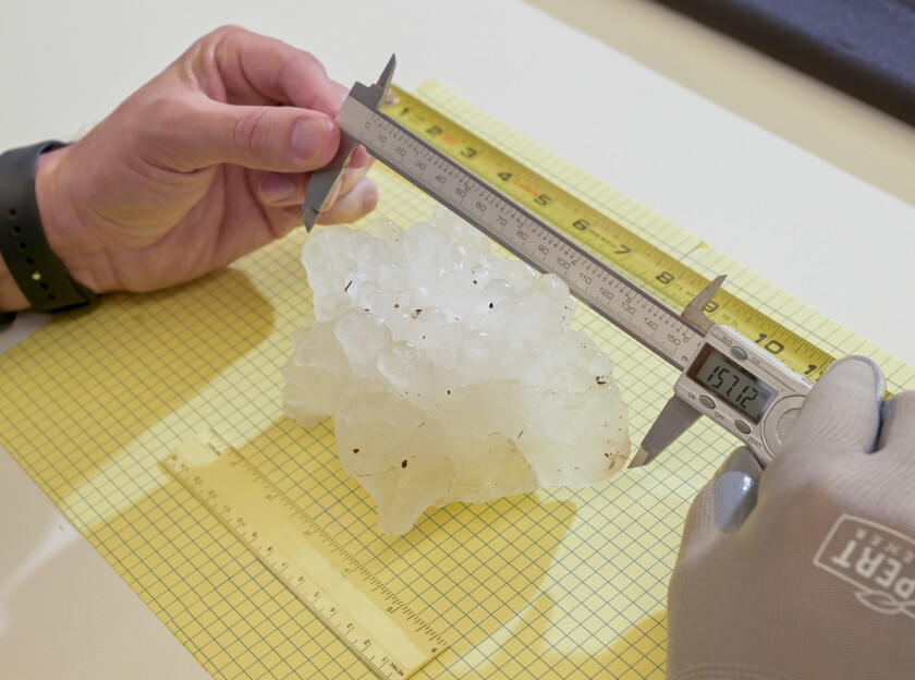 Mega hailstone officially broke state record during 'most severe year for weather in recent memory' 2026 - justice Victor gensini, a meteorologist at northern illinois university, measures the record-breaking hailstone back in march.
