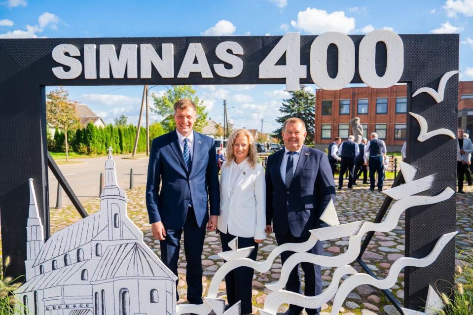 Simno jubiliejaus šventės dalyviai prie dekoracijos „simnas 400“.