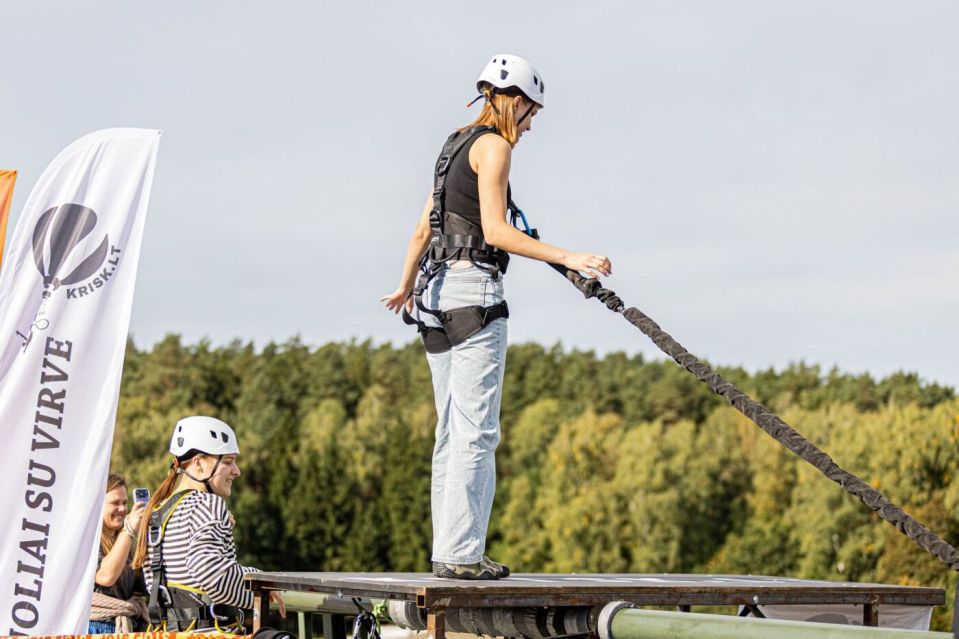 Virš nemuno – kvapą gniaužiantys šuoliai: alytuje surengtas išskirtinis base renginys 2026 - teisingumas - iustitia. Bg Dalyvė su saugos apraišais ant šuolių platformos