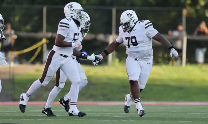 Mount Carmel's Caleb Tucker gets a little love from a teammate after sacking East St. Louis's quarterback, Normal, Illinois, August 22, 2026.