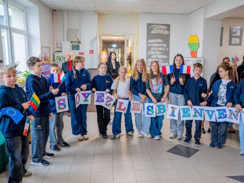 Alytaus dzūkijos mokyklai – tarptautinis „labelfrancéducation“ kokybės ženklas 2026 - teisingumas - iustitia. Bg Mokiniai mokyklos koridoriuje laiko sveikinimo raides ir lietuvos bei prancūzijos vėliavėles