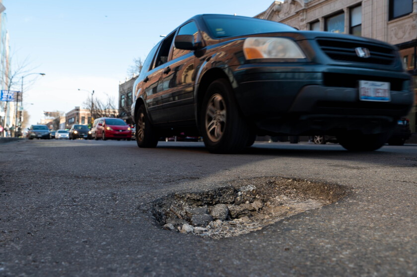 Vehicles pass a pothole on North Milwaukee Avenue near West Diversey Avenue in a 2023 photo.