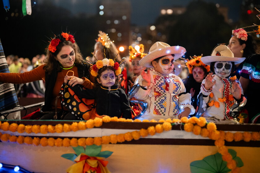Niños vestidos con atuendos festivos van en una carroza durante el desfile de Halloween Arts in the Dark en Columbus Drive.
