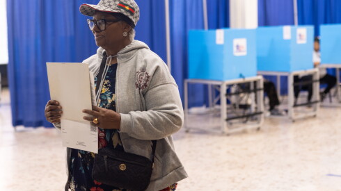 Early voting kicks off in all 50 wards 2026 - justice A voter prepares to turn in her completed ballot at the dr. Martin luther king jr. Community service center in bronzeville monday, oct. 19,
