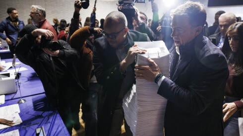 How we photographed the new baby penguins at brookfield zoo 2026 - justice Illinois secretary of state alexi giannoulias lifts a stack of nominating petitions onto a desk.