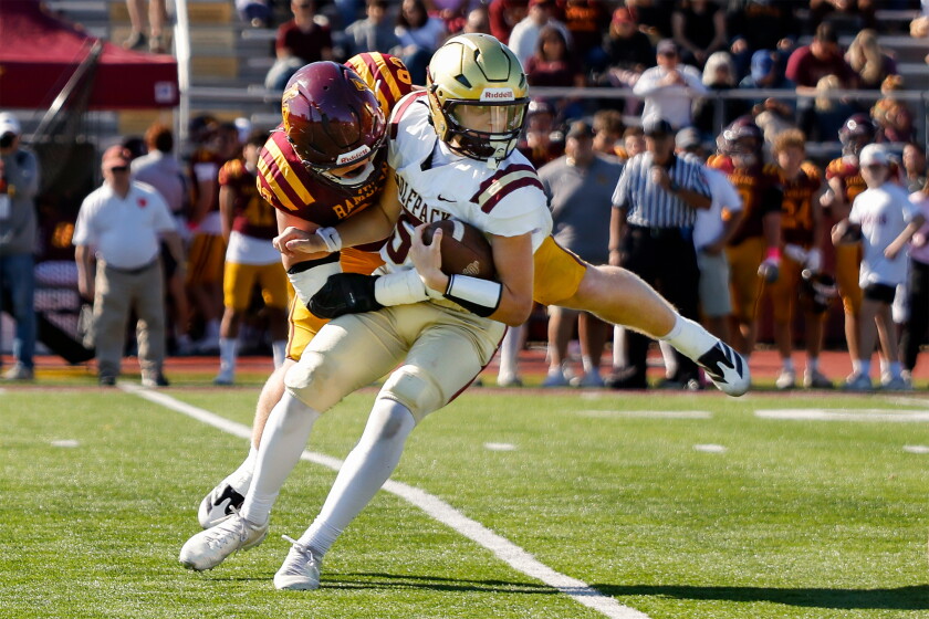 St. Igantius' Reid Hites (5) is sacked by Loyola’s Braedan McHugh (92).