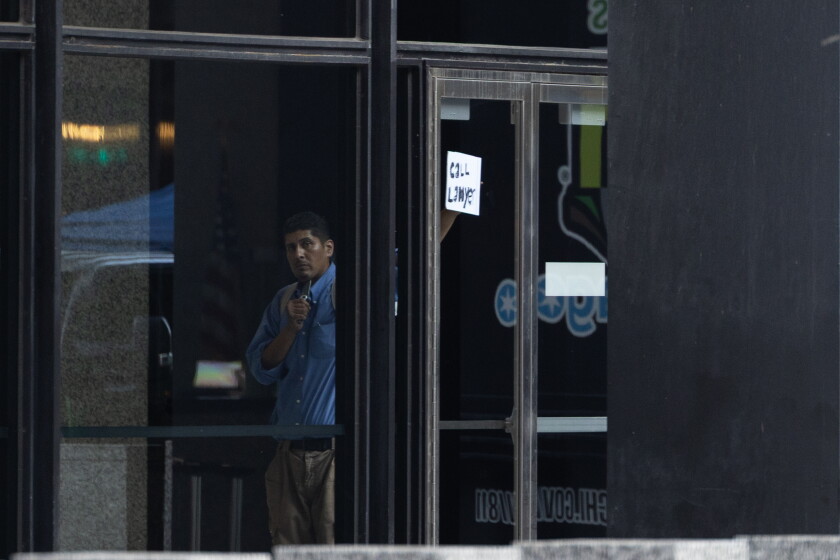 Man who caused shutdown at chicago's federal courthouse pleads guilty, faces 2 years in prison 2026 - justice Mario santoyo holds a sign saying "call lawyer" while barricading himself in the lobby of the dirksen federal courthouse in july 2025.