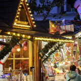 Besucher gehen über den weihnachtsmarkt in essen steele. Buden mit süßigkeiten sind zu sehen.