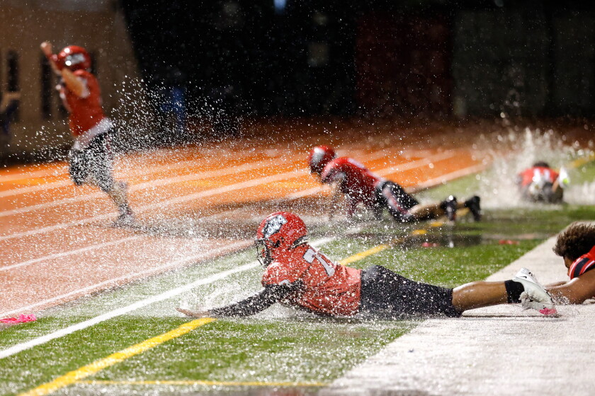 The dive after five overtimes: lake view beats von steuben in rain-soaked thriller 2026 - justice Lake view football players dive into puddles after winning the game against von steuben at lane stadium.